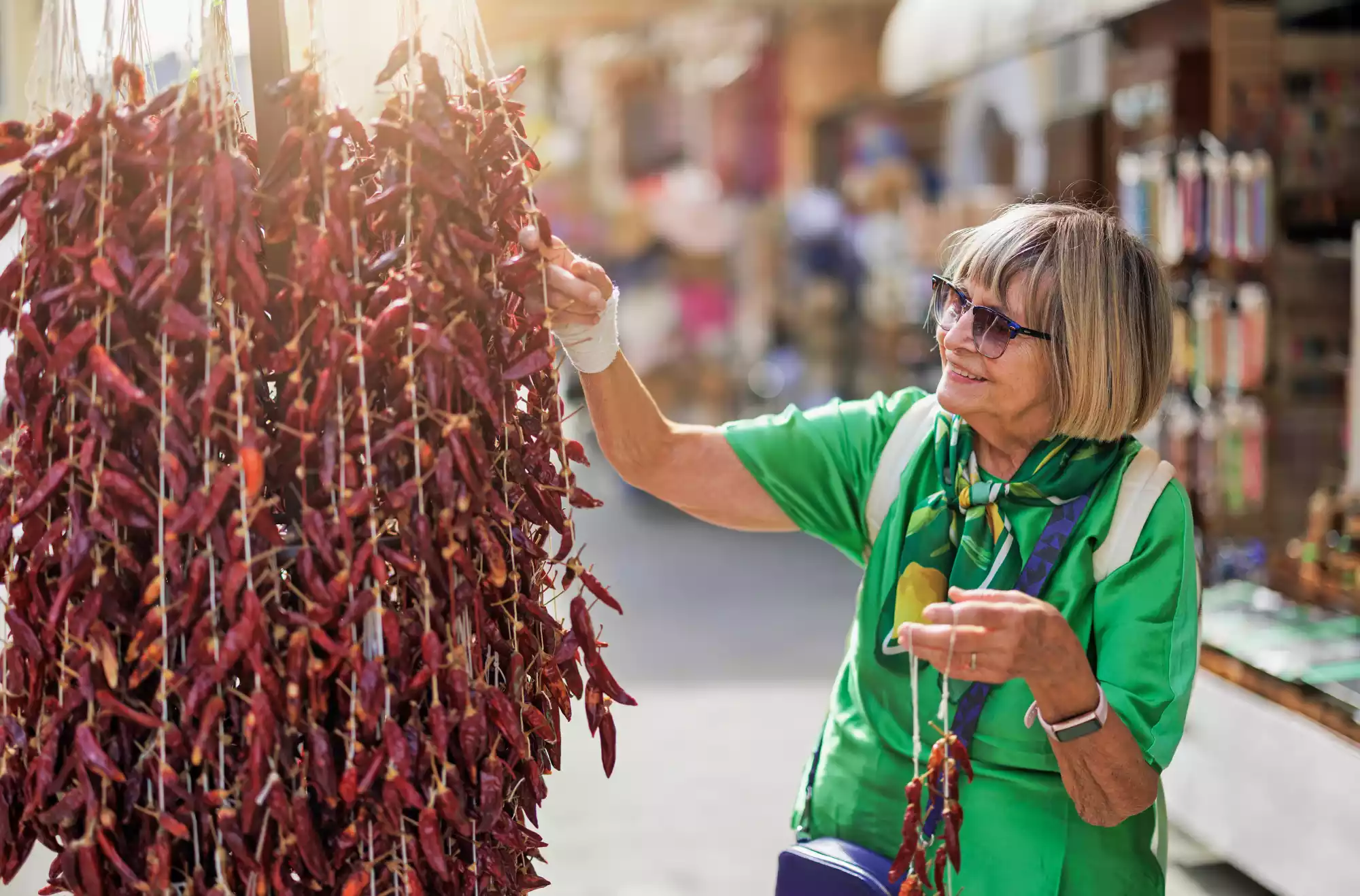 Turista osserva mazzi di peperoncino essiccato in un mercato tradizionale in Calabria