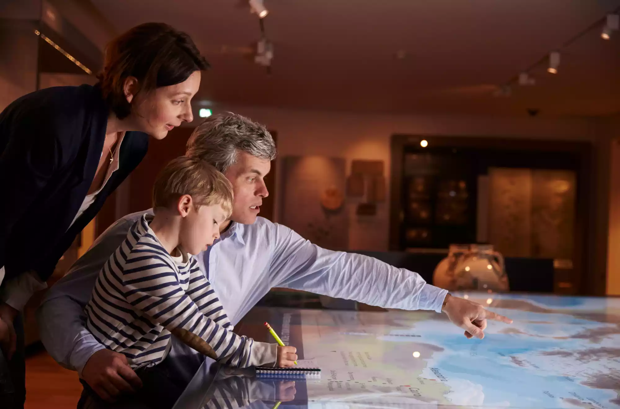 immagine rappresentativa di edutainment con una famiglia in visita a un museo interattivo