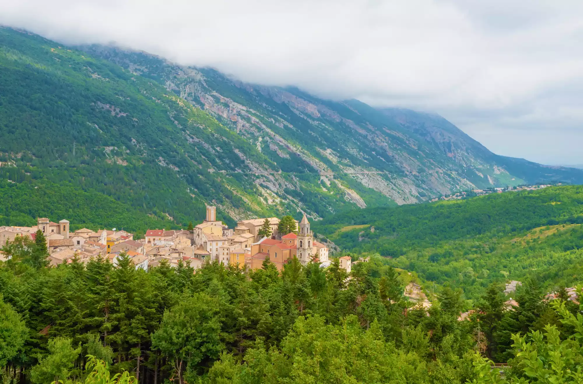 vista sui boschi del parco nazionale della Majella in Abruzzo, con un panorama su un borgo tipico della zona.