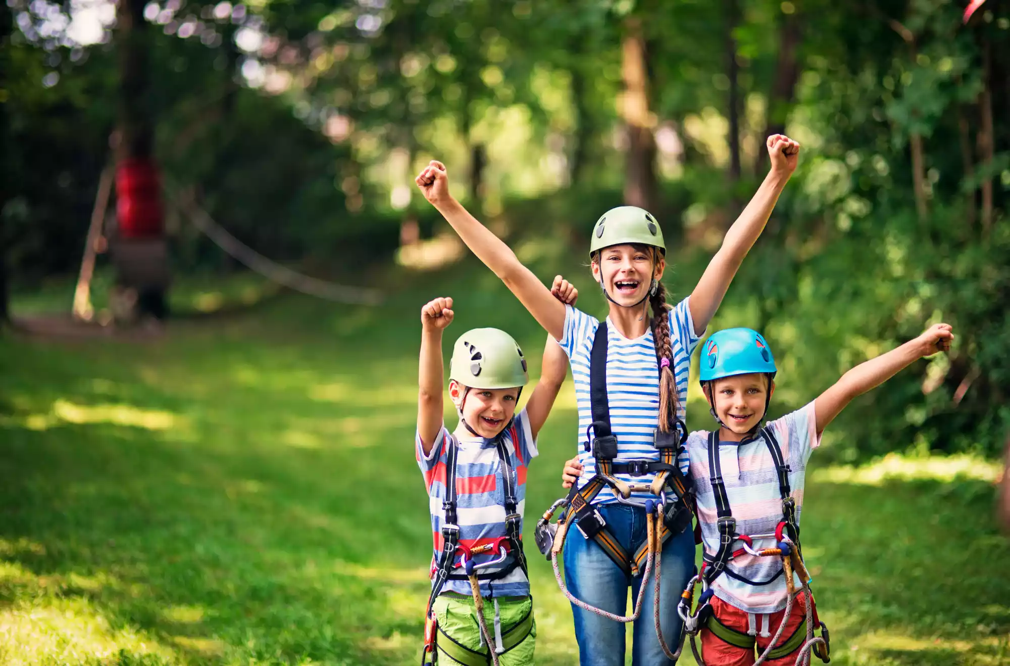 Bambini che si divertono nel parco avventura con percorsi acrobatici