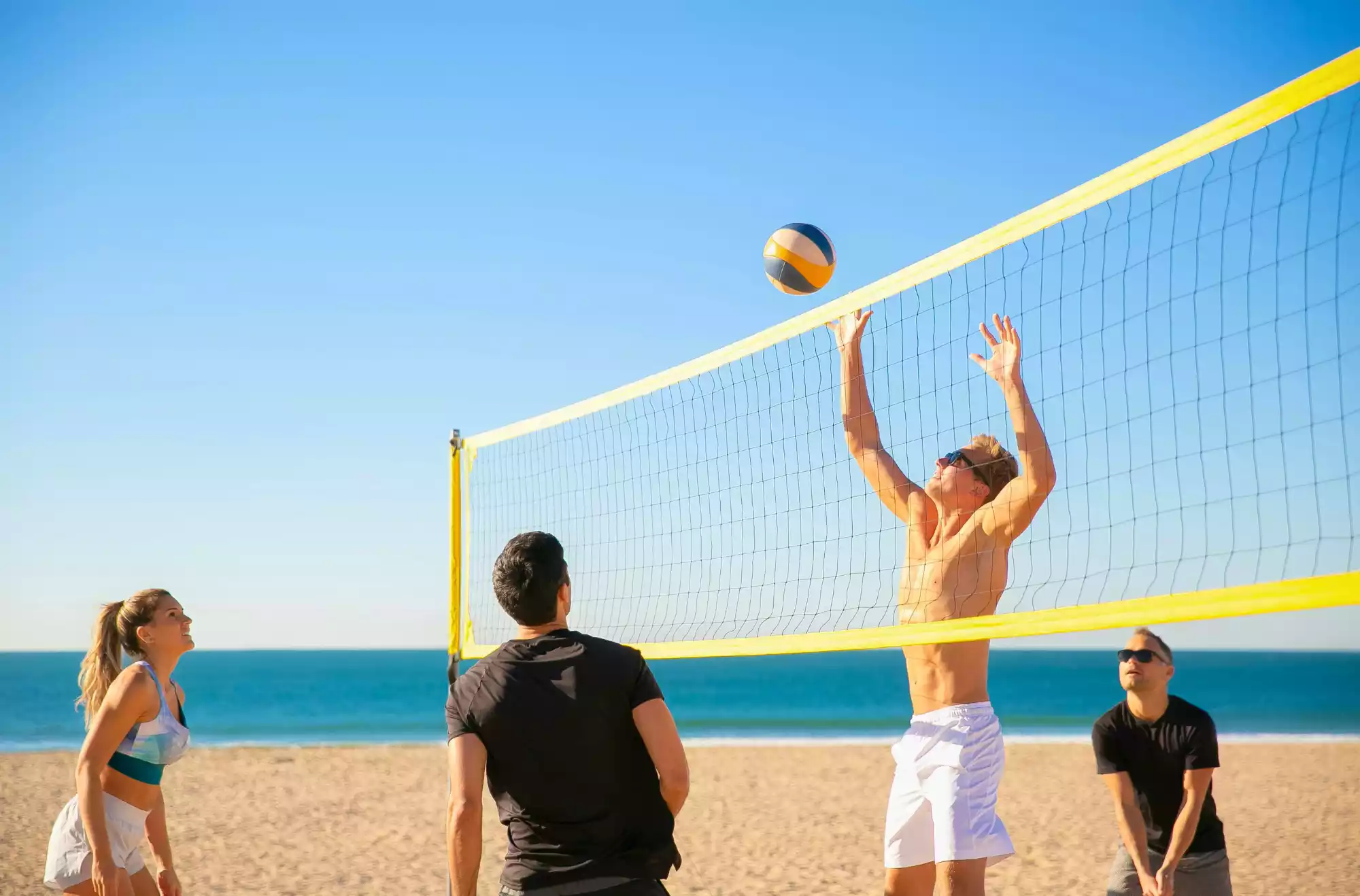 ragazzi che giocano a beach volley in spiaggia