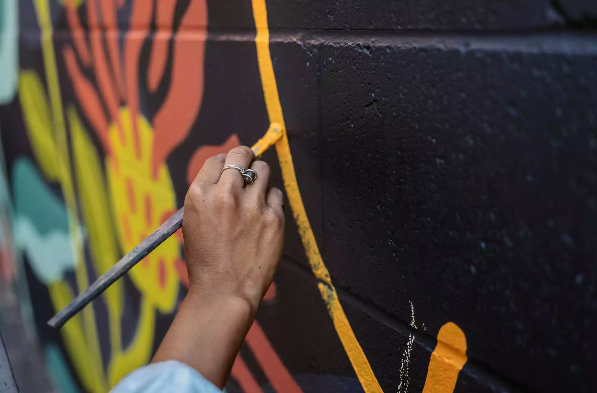 Artista a lavoro nella realizzazione di un murales