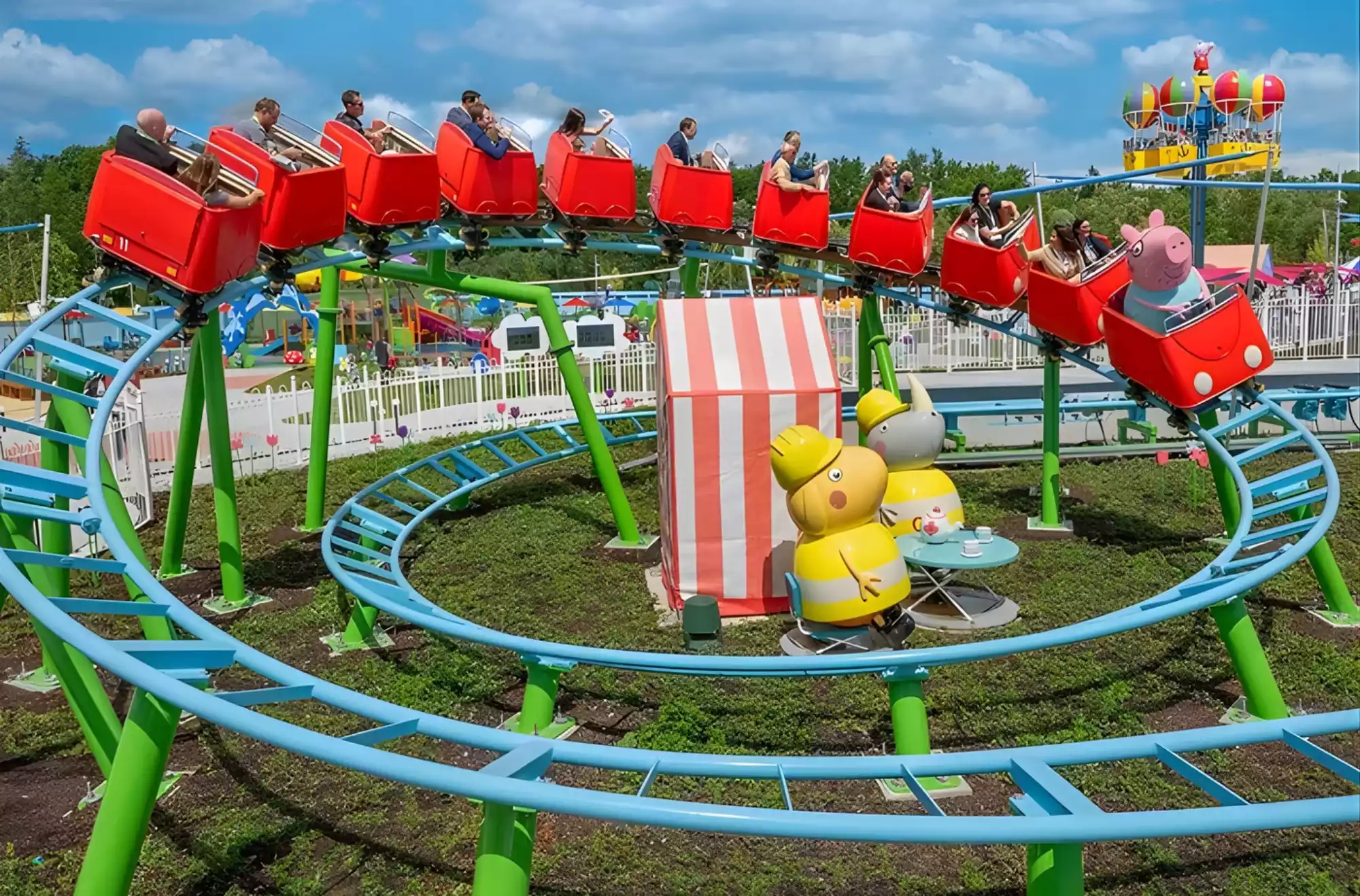 Famiglie a bordo delle montagne russe di Papà Pig nel PEPPA PIG Park di LEGOLAND Germania, attrazione perfetta per i bambini più piccoli.