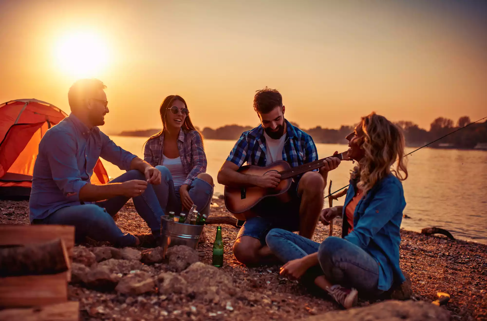 foto rappresentativa di un gruppo di ragazzi che fanno musica in spiaggia
