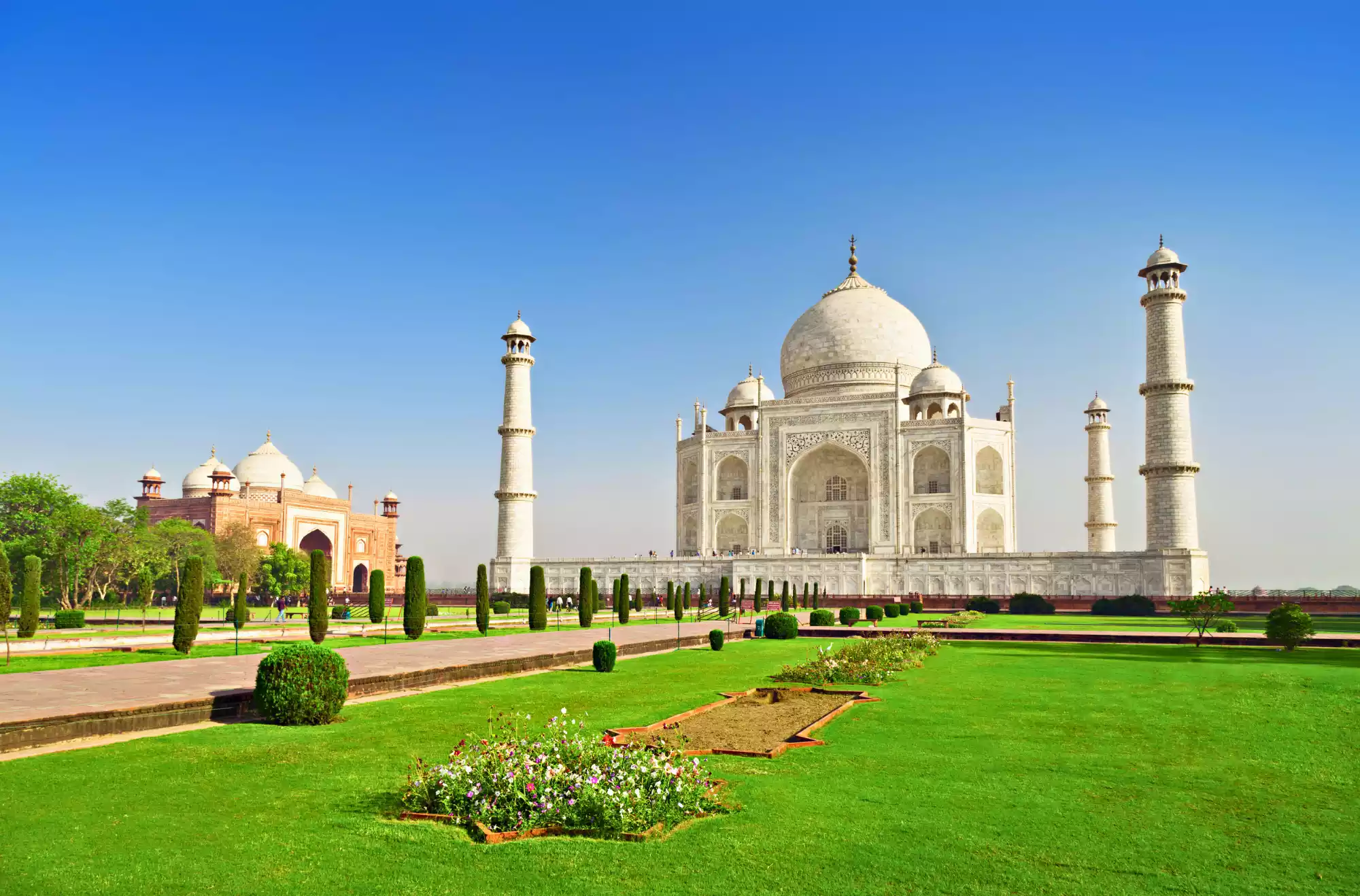 Il Taj Mahal di Agra in India è considerato uno dei monumenti più belli del mondo ed è entrato nelle 7 meraviglie del mondo. In foto il monumento con la grande cupola e i minareti agli angoli. Porzione del giardino persiano suddiviso dai canali.